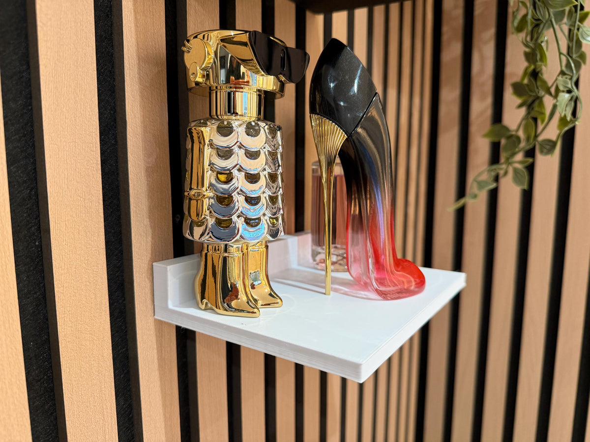 White perfume shelf on a slat wall displaying two decorative perfume bottles, close angle