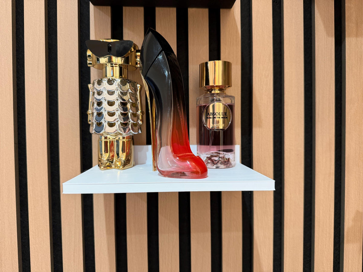 White perfume shelf on a slat wall displaying two perfume bottles