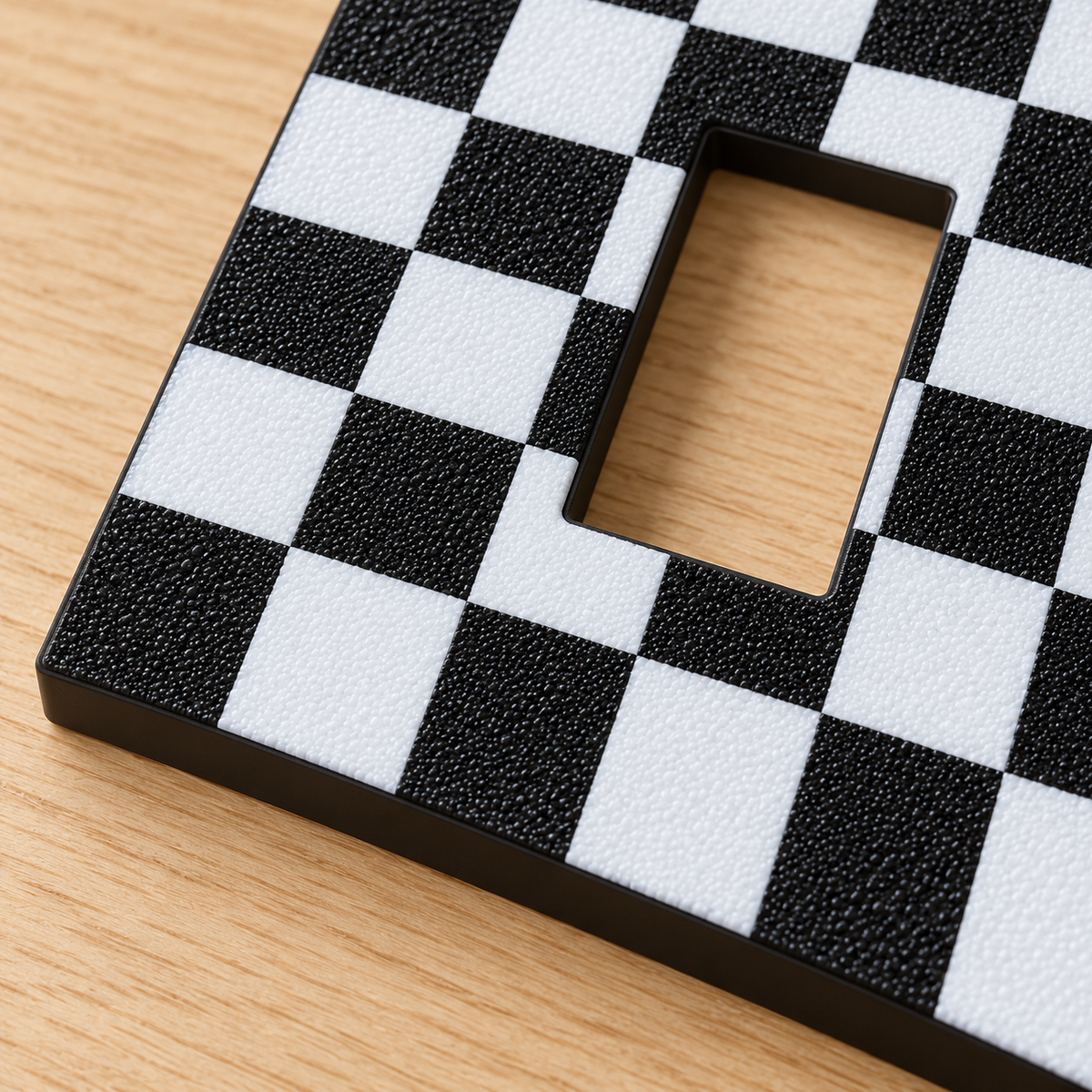 Black and white checkerboard light switch surround on a slat wall